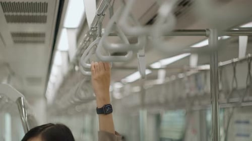 Close up businesswoman hand is holding skytrain handle on Metro train