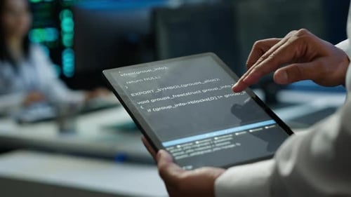 Close Up of Tablet Used By IT Worker Doing Maintenance on Server Farm Gear