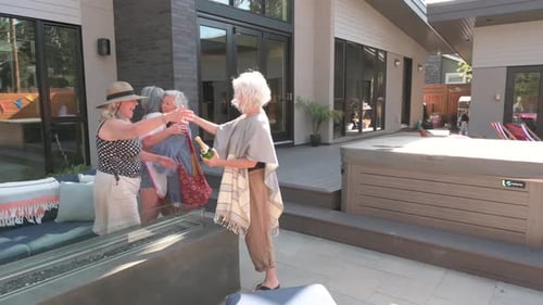Senior Women Friends Embracing in Modern Backyard Patio
