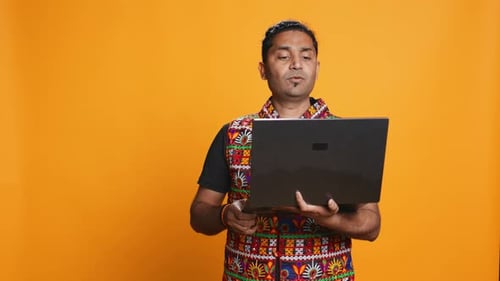 Man with Friends in Teleconference Meeting Using Laptop Studio Background