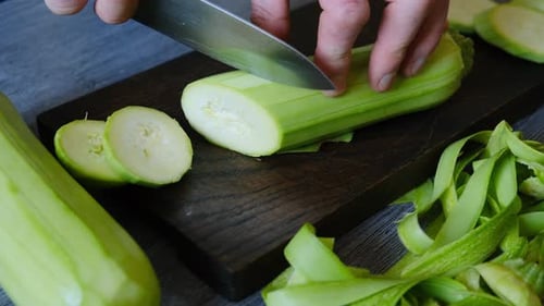 Slicing Fresh Zucchini on a Wooden Cutting Board