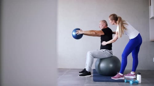 Man Working Out with his Trainer at Home