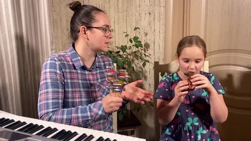 Girl Plays Wind Instrument with Adult