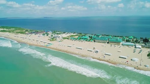 Aerial Over the Long Sandy Spit with a Beach and Azure Water on a Sunny Summer Day Waves Crashing to