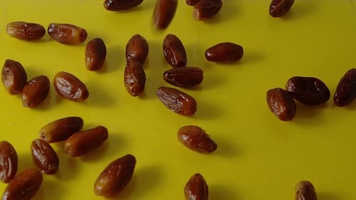Dates Dropping onto Yellow Surface in Studio