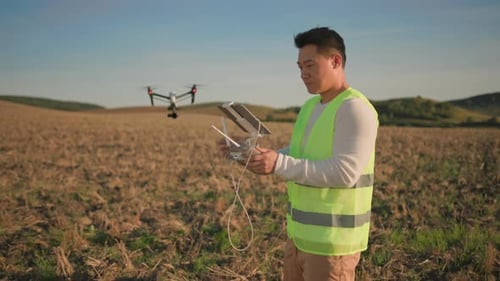 A Drone Operator Diligently Works in an Agricultural Field Utilizing Modern HighTech Equipment