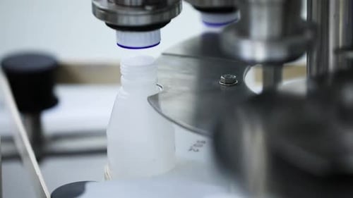 Bottle capping automatic Cough syrup getting caps in automatic Medical white bottle getting capped b