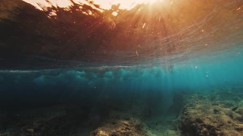 Vue sous-marine de la vague qui se brise aux Maldives au coucher du soleil