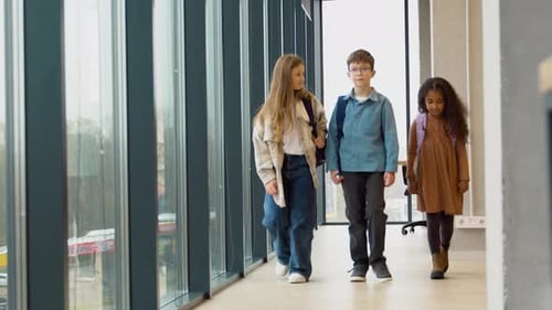 Happy Diverse Multiethnic Kids Junior School Students Group Walking in a School Corridor Back to