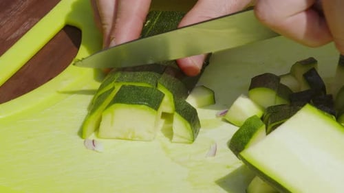 Dicing Green Zucchini on Yellow Cutting Board