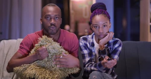 Young Adult Couple Watching Scary Movie at Home
