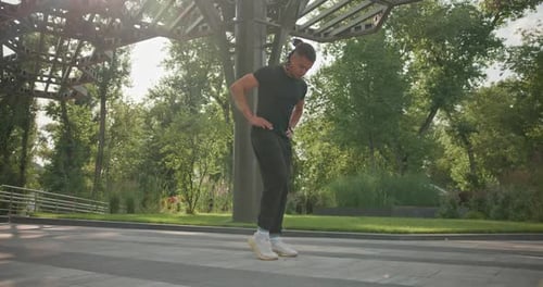 Young Adult Leg Stretches in Park