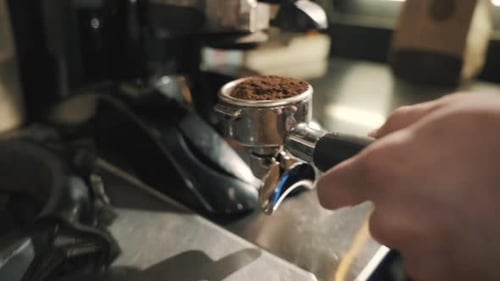 Freshly ground coffee tightly packed in the filter holder in a close-up.