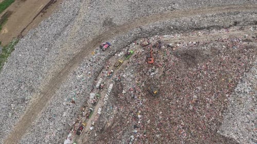 Aerial view of garbage trucks at a landfill site