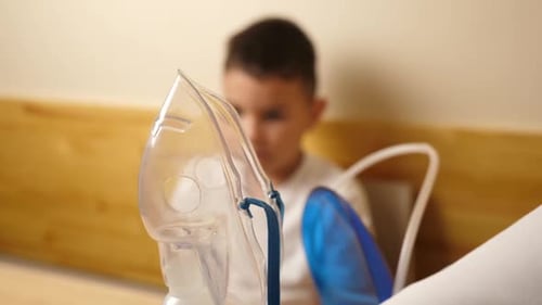 1. Le garçon se prépare pour la procédure d'inhalation par nébuliseur.