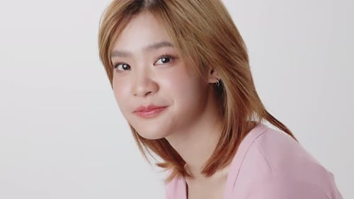 Slow motion shot close up face of Young Asian girl on white background.
