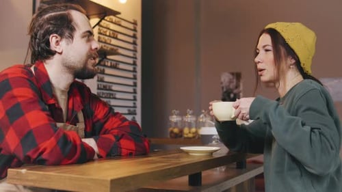 Barista and Customer Share a Moment While Enjoying Coffee in a Cozy Artisan Cafe During the Morning