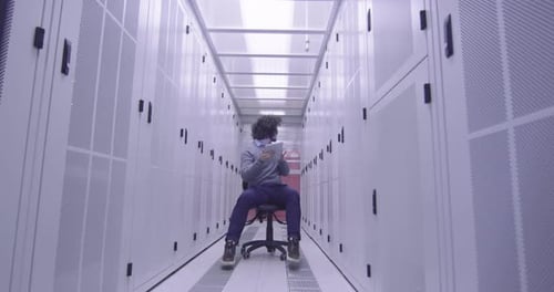 Ingénieur informatique ou spécialiste de la science des données travaillant sur une tablette dans une salle de serveurs dans un cloud moderne