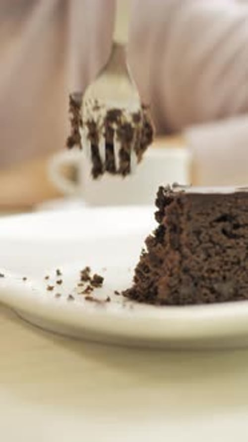 Fork Takes Bite of Rich Chocolate Cake