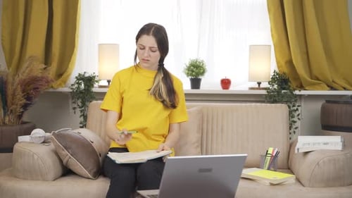 Young Woman Studying and Taking Notes at Home