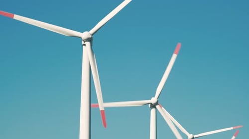 Large rotating wind turbine blades against the blue sky