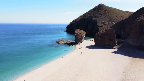 Drone aerial view of seashore, coastline, scenic view of people at unspoiled beach