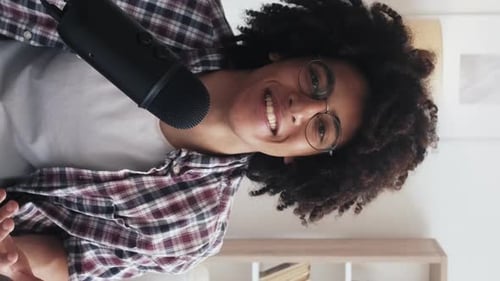 Young Adult Talks Into Microphone in Vertical Video