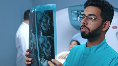 Medical Doctors Working in Modern Hospital Office Holding and Thoughtfully Looking at MRI Scan with