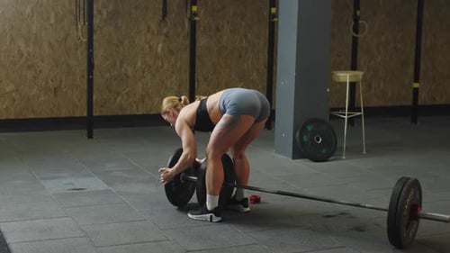 Weightlifting practice in slow motion showcasing strength and focus in gym setting