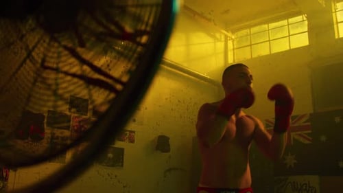 Shirtless Man Practicing Boxing Punches in Gym