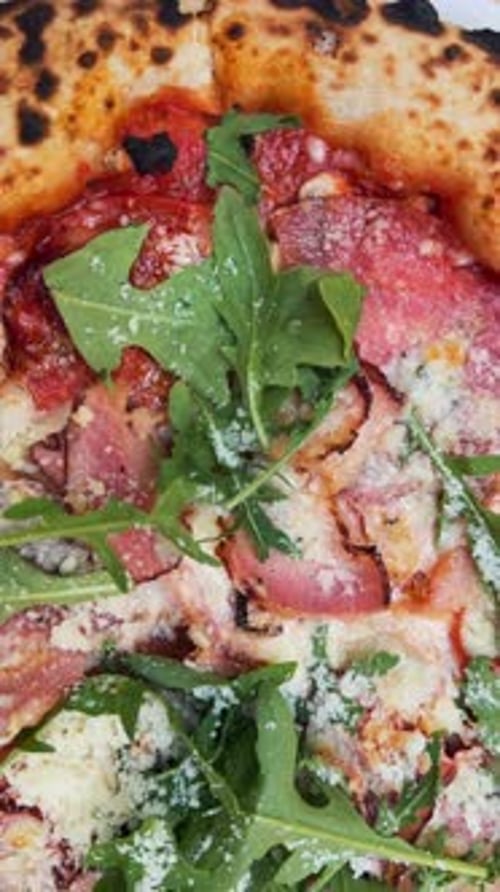 A Detailed Shot Taken Up Close Featuring a Tasty Pizza on a Table Situated on the Terrace