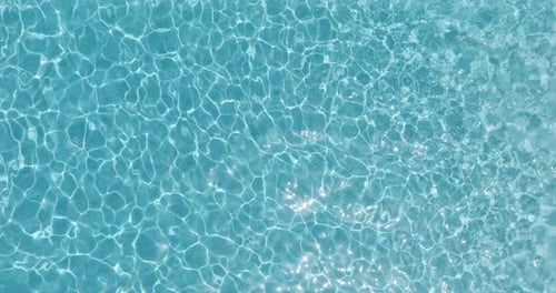 Blue Water in the Swimming Pool with Light Reflections