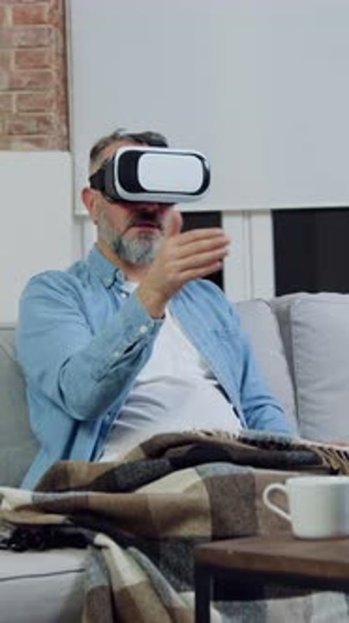 Man Enjoys Virtual Reality Experience on Home Sofa