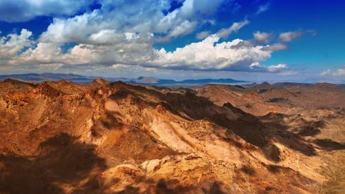 Beautiful fluffy clouds throw their shadows on the bare rocks. Scenic view of the mountains