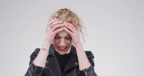 4k video footage of a stressed out young woman standing against a grey background