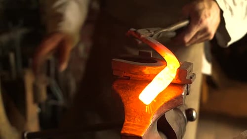 Blacksmith Shaping Glowing Metal Horseshoe on Anvil