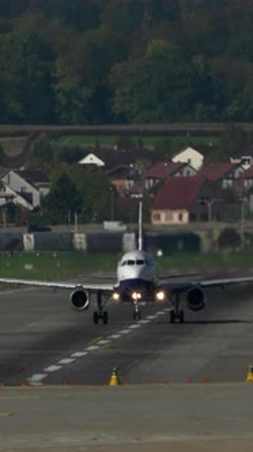 An Airplane is Landing at an Airport That Has a Beautiful and Scenic Background View
