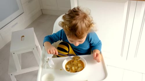 A criança come a sopa do prato