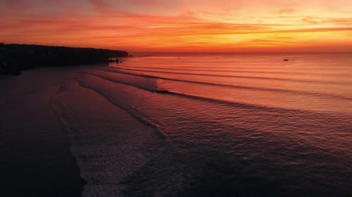 Coastline Landscape with Warm Sunset or Sunrise and Ocean with Surfing Waves in Bali