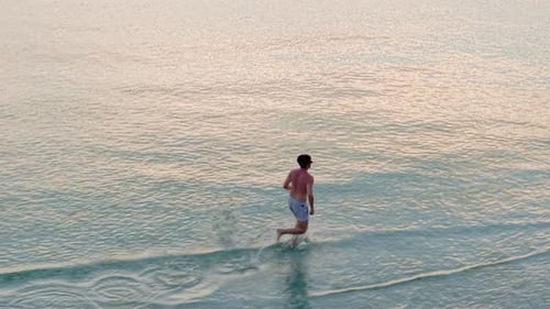 Man Running on Beach at Sunrise
