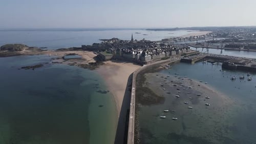 Môle des Noires lighthouse with Saint-Malo Intra-Muros in background, Brittany in France. Aerial rev