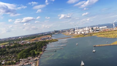 Aerial drone view of the coastline near Amager Strandpark, with sailboats in the water and CopenHill
