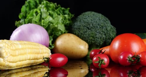 Fresh vegetables arranged on a reflective surface