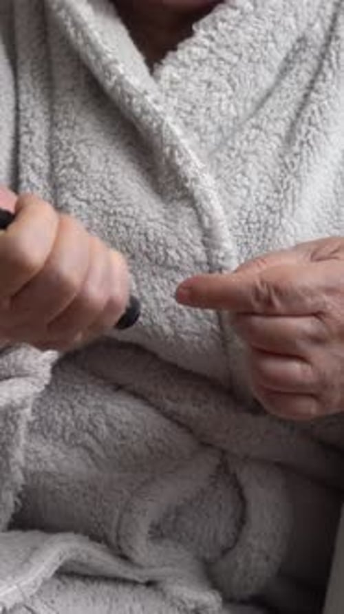 Adult Tests Blood Sugar with Electronic Device