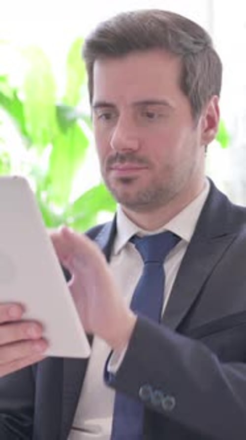 Young Businessman Using Digital Tablet in Office, vertical video