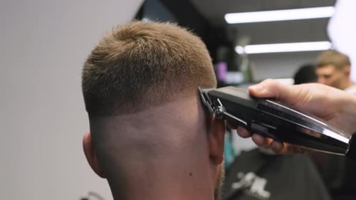 Man Getting Haircut With Electric Trimmer in Barbershop