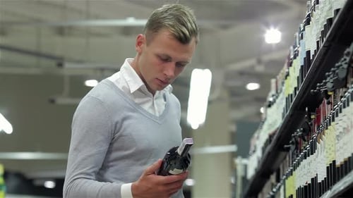Handsome Looking at Wine Bottle