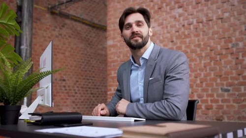 Young Businessman in Office Working on Pc and Looking at Camera