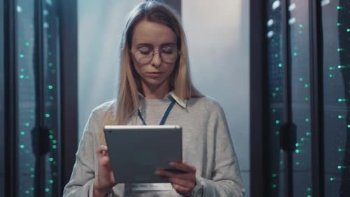 Woman Uses Tablet in Server Room Data Center