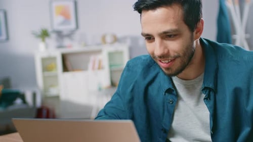 Excited Young Man Celebrating Success with Laptop
